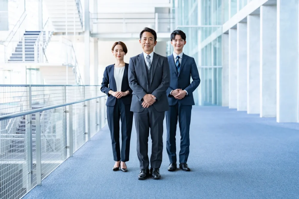 スーツ姿の男性と女性が笑顔で立っている姿