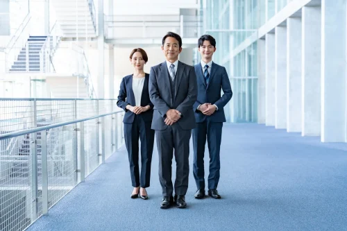 スーツ姿の男性と女性が笑顔で立っている姿