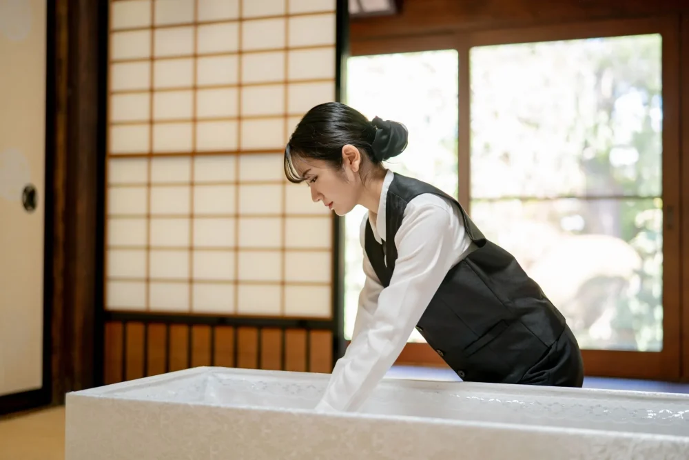 棺の中を整えている女性