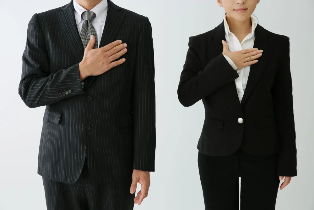 胸に手を当てている男性と女性