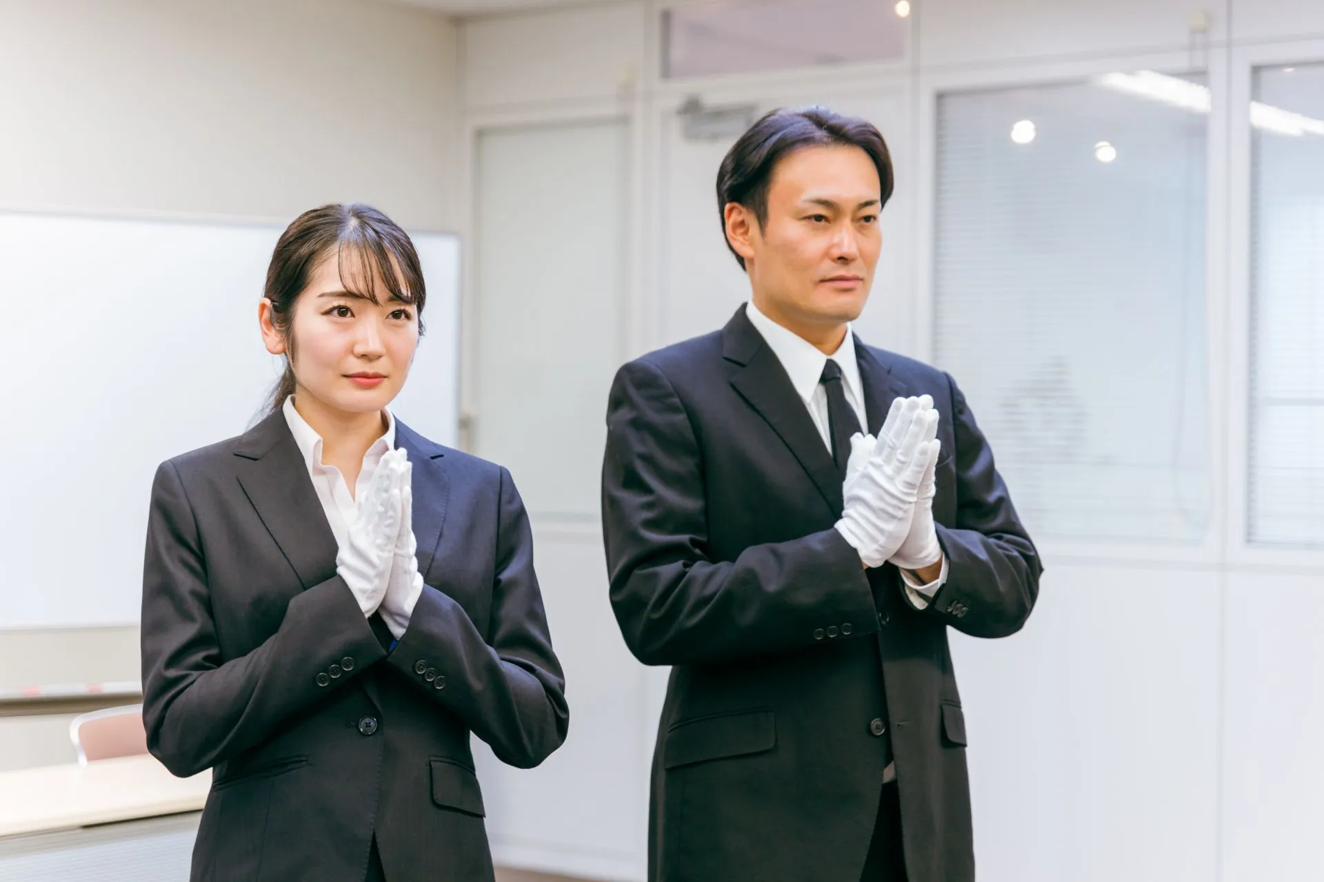 神妙な面持ちで合掌をしている男性と女性